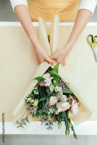 Florist making a bouquet of beautiful blooming eustomas photo