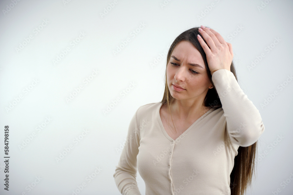 Stressed young brunette lady is having headache and fever. She is wearing yellow tshirt and stands on light background, holding forehead. High quality photo Stressed young brunette lady is having headache and fever. She is wearing yellow tshirt and stands on light background, holding forehead. High quality photo