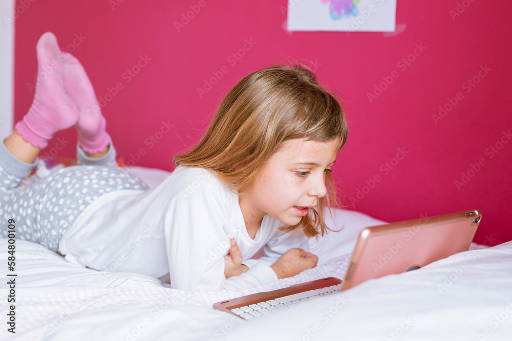 Girl lying on the bed with tablet Girl lying on the bed with tablet