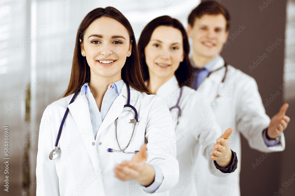 Doctors are standing as a team while offering their helping hands for shaking hand or saving people's life. Physicians are ready to help their patients. Medical help Doctors are standing as a team while offering their helping hands for shaking hand or saving people's life. Physicians are ready to help their patients. Medical help