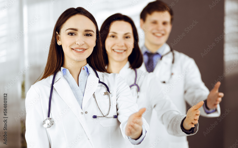 Doctors are standing as a team while offering their helping hands for shaking hand or saving people's life. Physicians are ready to help their patients. Medical help Doctors are standing as a team while offering their helping hands for shaking hand or saving people's life. Physicians are ready to help their patients. Medical help