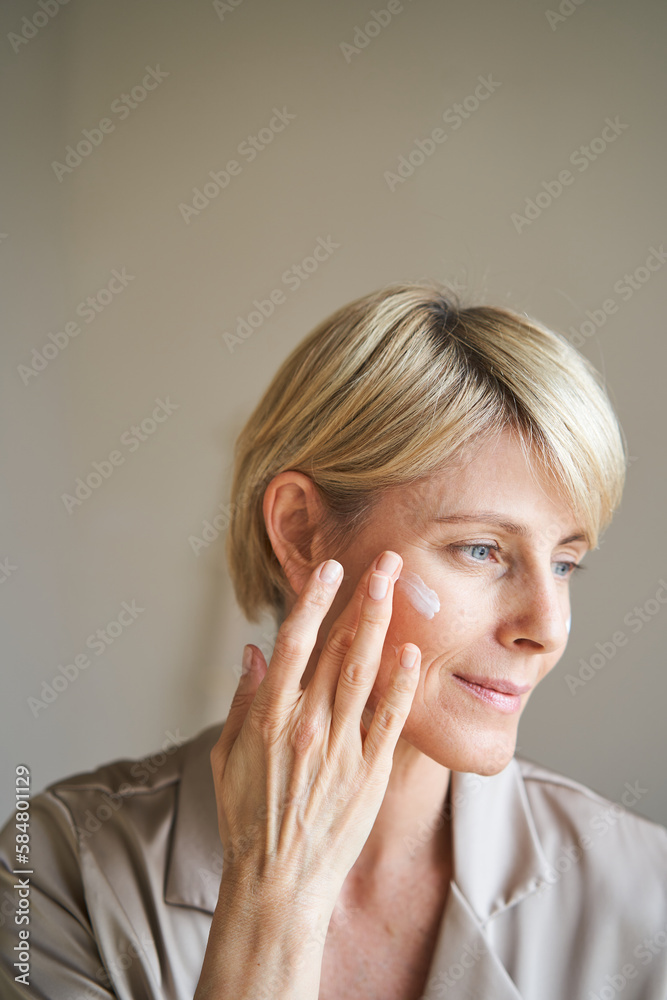 Middle aged female moisturizing face
