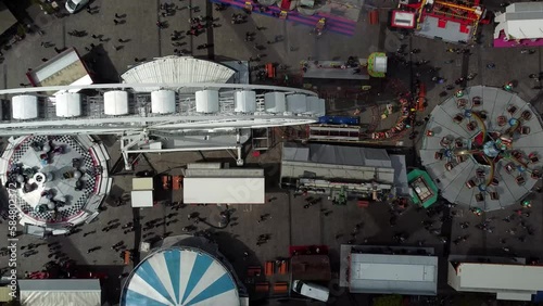 Aerial time lapse of fair showing several funfair attractions like ferris wheel and wave swinger is amusement ride that is a variation on the carousel in which the seats are suspended from rotating 4k photo