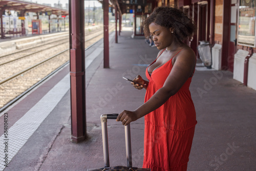 woman tourist using phone on railway station, travel by train photo