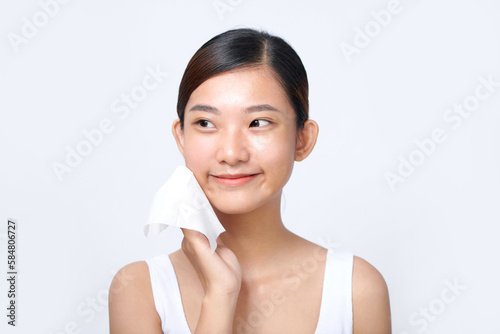 young woman removes her makeup with a wet tissue photo