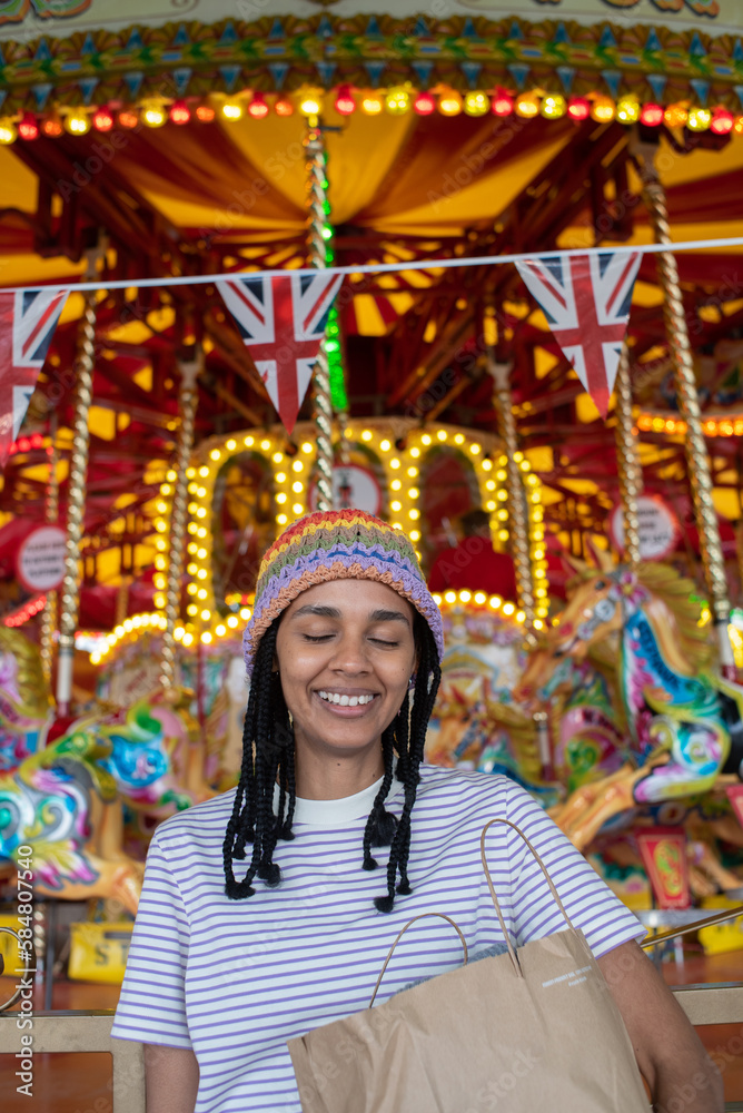 Timid young woman laughing at amusement park