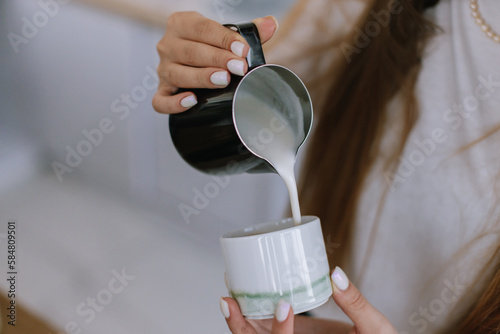 Faceless bartender Pouring Milk into Cup photo