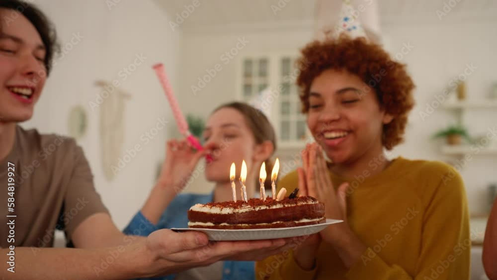 African american girl celebrates birthday with friends blows candles on