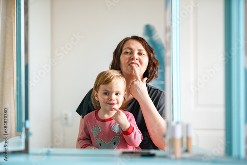  kid and mature mother exercises facial expressions  photo