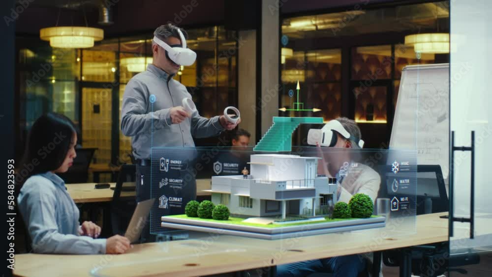 Male designer uses VR headset and wireless controllers, presents smart home exterior design project in virtual reality to coworkers. Modern hi-tech company. 3D hologram. Future digital technologies.