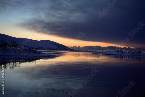 landscape sunset in snowy nature and sea in tromso