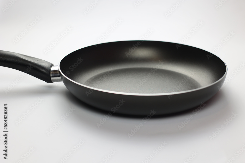 Empty frying pan on a white background. Close-up of black kitchen utensils. Preparation for frying. Preparing breakfast. Frying pan Black metal utensils. Empty frying pan on a white background. Close-up of black kitchen utensils. Preparation for frying. Preparing breakfast. Frying pan Black metal utensils.