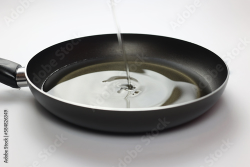 Empty frying pan with oil. Oil is poured into the pan. Close-up of black kitchen utensils. Preparation for frying. Preparing breakfast. Frying pan Black metal utensils. Lots of oil for fries