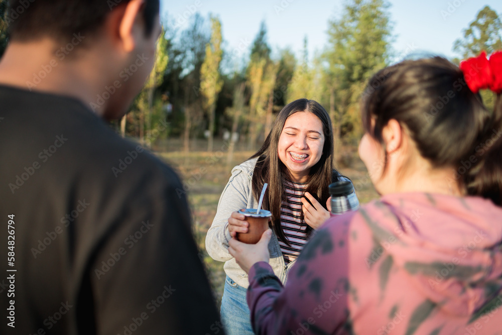 Three cheerful friends drinking yerba mate in the countryside at sunset. Three cheerful friends drinking yerba mate in the countryside at sunset.