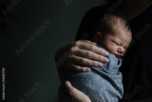 Newborn being held by mother.