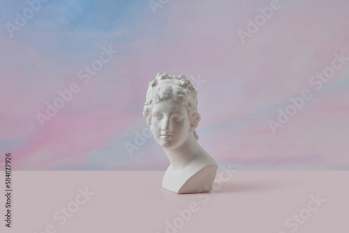 Antique bust against soft pink background.