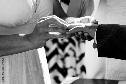 Mãos dos noivos no memento da troca de alianças em uma cerimonia de casamento. photo