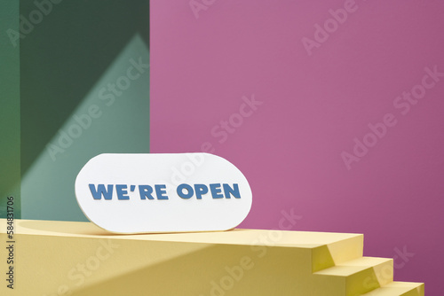 Come in we're open, white wooden sign on yellow photo