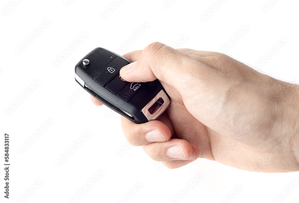 Unlocking a car with button on the keychain. Man's hand holds car key on white background close up. Unlocking a car with button on the keychain. Man's hand holds car key on white background close up.
