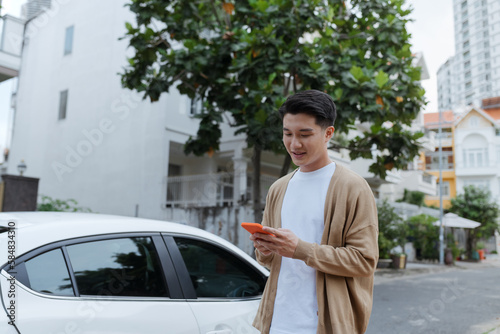 Man holding smartphone near the car. photo