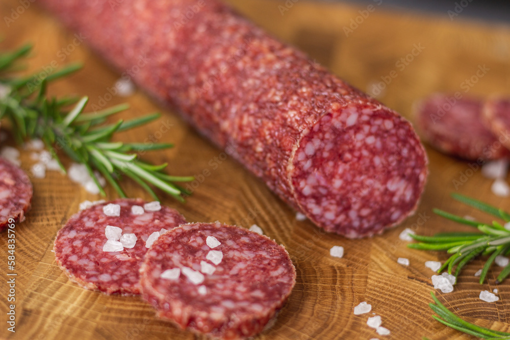Sausage on a wooden board. Sausage with raspberry and salt. Sausage on top. Macro Sausage Sausage on a wooden board. Sausage with raspberry and salt. Sausage on top. Macro Sausage