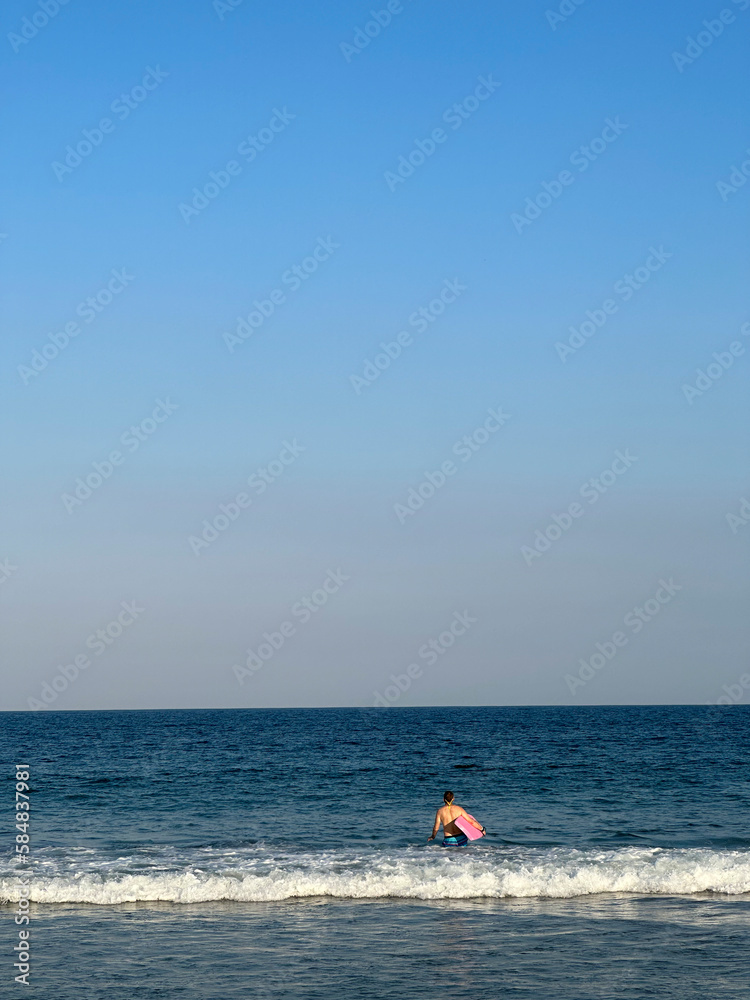 Rear View Of a child Running Into Sea With Bodyboard On Beach Vacation, Lauderdale By The Sea, Florida