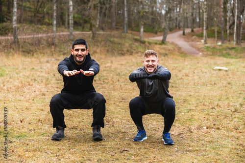 Workout partners doing squads outdoors