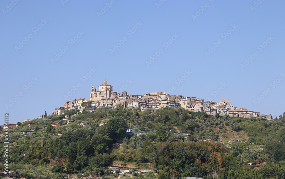 View of a typical mountain village with meadow, trees and steppe in Abruzzo in summer in Italy