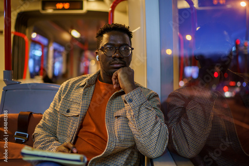 Writer thinking of story while riding bus at night photo