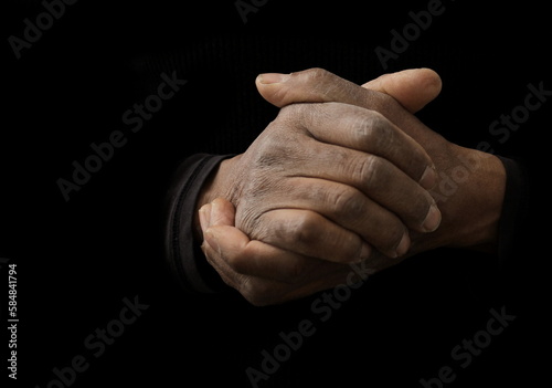 man praying to god with hands together Caribbean man praying with black background stock photos stock photo 