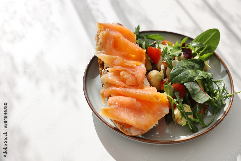 Open sandwich or toast. Grain bread with salmon, salad from avocado, ruccola and mozarella cheese. Healthy snack, fat and omega 3 source copy space white background top view copy space Open sandwich or toast. Grain bread with salmon, salad from avocado, ruccola and mozarella cheese. Healthy snack, fat and omega 3 source copy space white background top view copy space