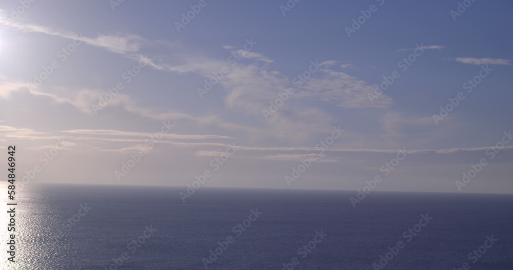 Fototapeta premium Composition of light trails over sea and sky with clouds