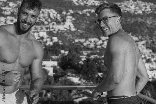 Cheerful muscular men standing on terrace photo