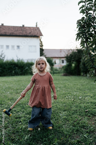 Girl harvests apples with a hammer photo