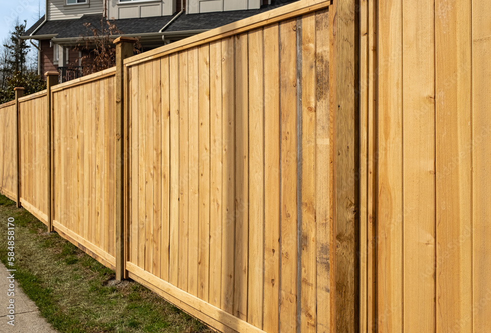 Nice new wooden fence around house. Wooden fence with green lawn. Street photo Nice new wooden fence around house. Wooden fence with green lawn. Street photo