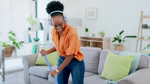 Music headphones, cleaning and black woman dance in home living room to remove dust or dirt for hygiene. Dancing, broom guitar and happy female cleaner singing while streaming radio, audio or podcast photo