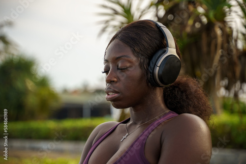 Woman listening to soothing music with her eyes closed in a park photo