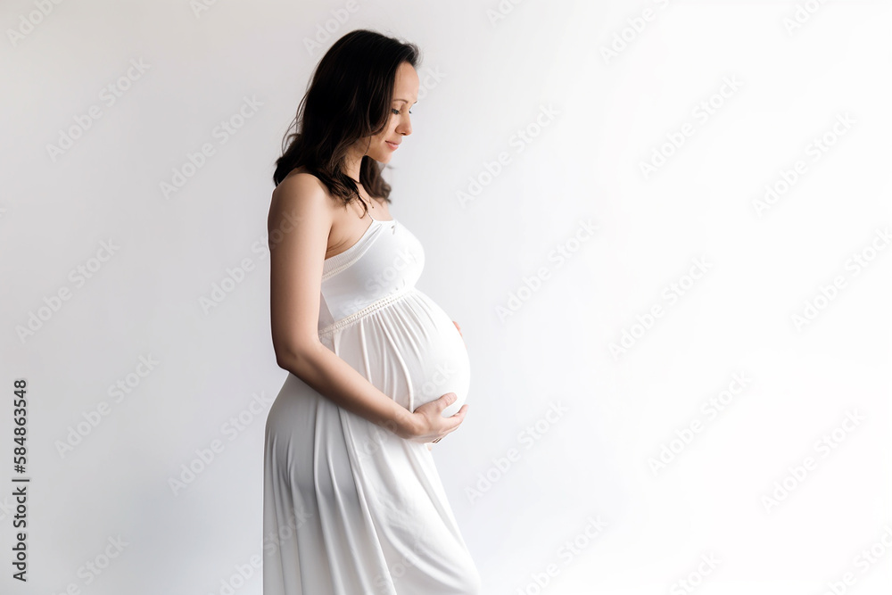 Mulher grávida sorrindo segurando a foto da barriga no estúdio Mulher grávida sorrindo segurando a foto da barriga no estúdio