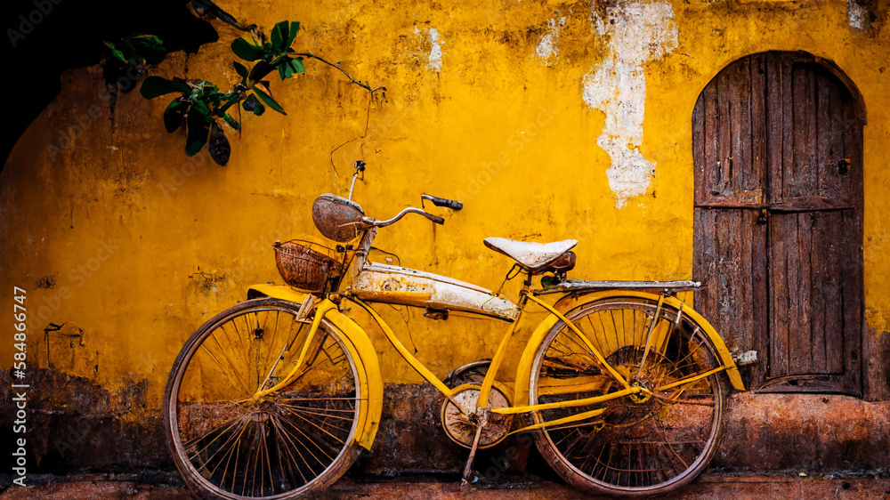 Vintage yellow bicycle leaning against retro wall. Tuscan vibe, old school travel