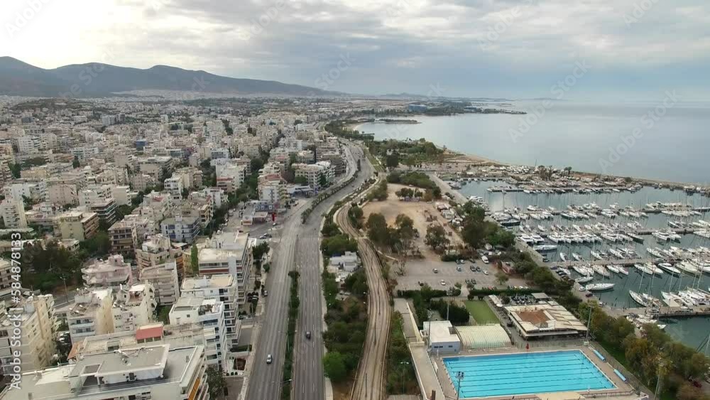 View from flying drone over Greek city of Athens, located between mountains and sea Bird's eye view from above of beautiful coastline of city of Athens modern buildings, roads, yachts in harbor, sea View from flying drone over Greek city of Athens, located between mountains and sea Bird's eye view from above of beautiful coastline of city of Athens modern buildings, roads, yachts in harbor, sea