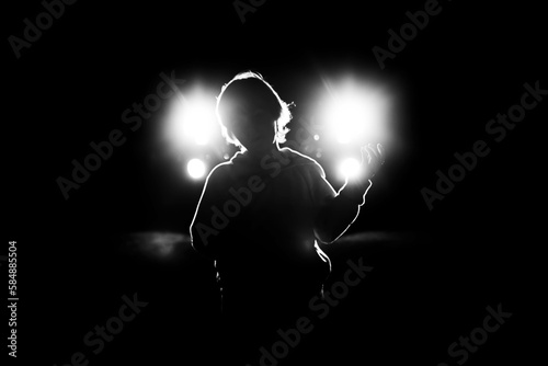 Young boy dancing in front of car headlights photo