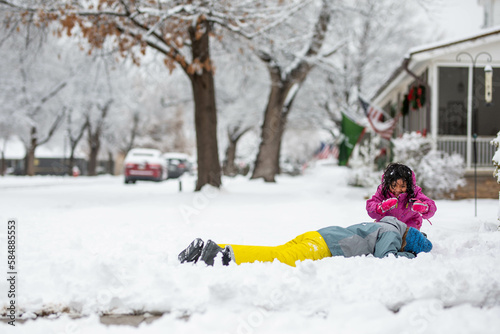 Kids playing in snow in neighborhood photo