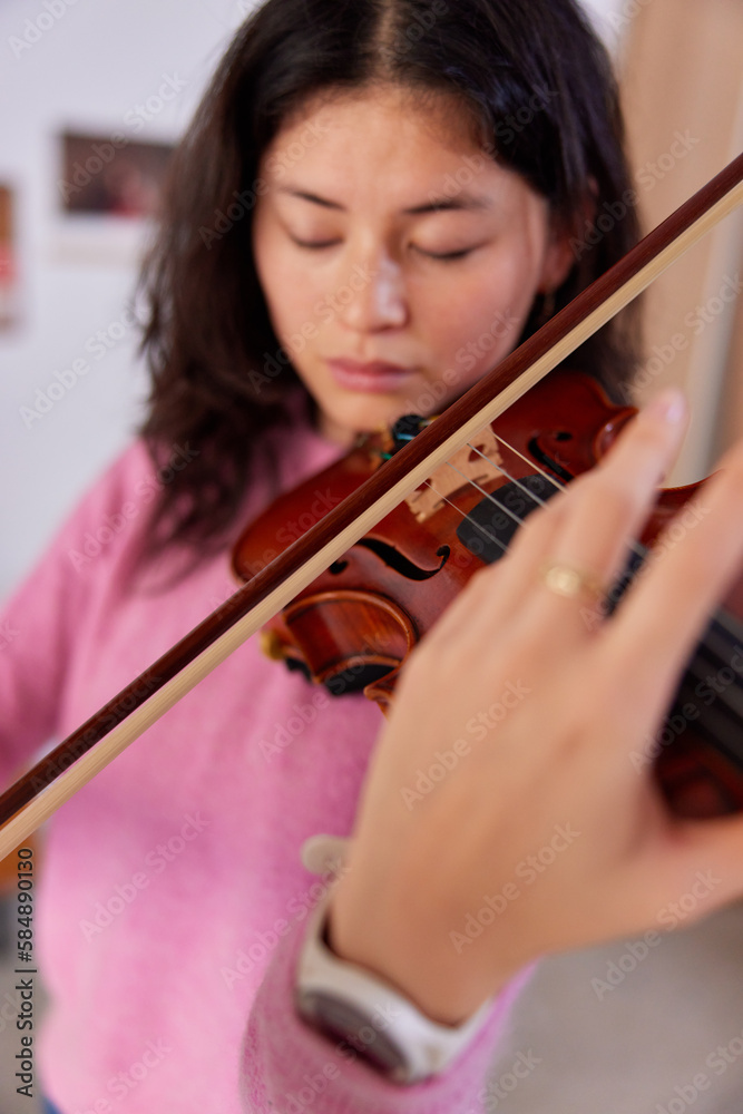 Young woman playing violin at home Young woman playing violin at home
