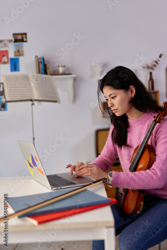Female violinist during online lesson at home