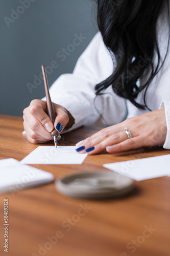 close up of hands writing calligraphy on paper