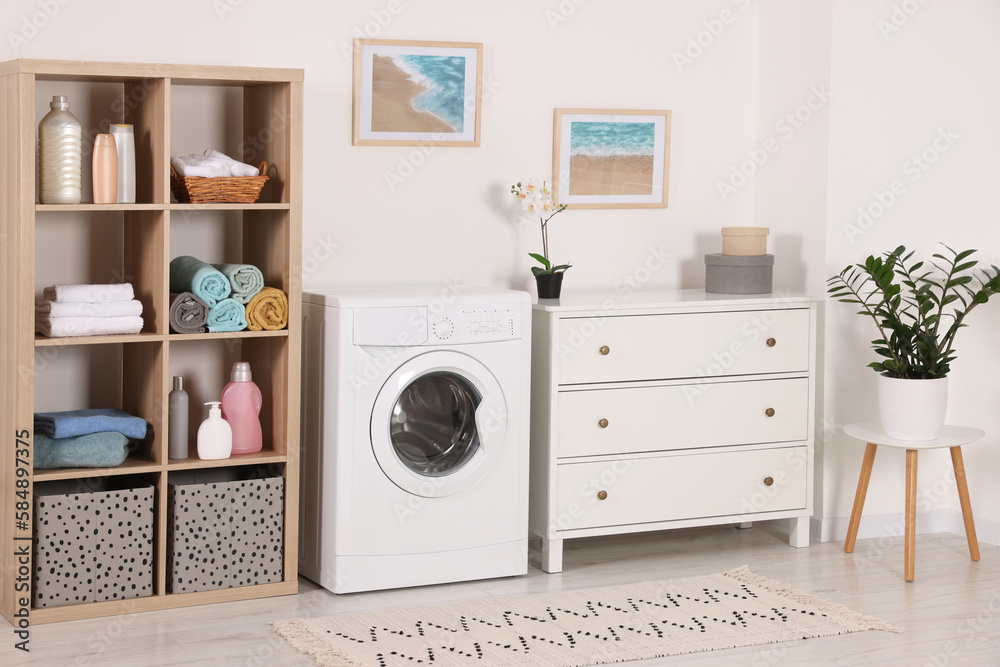 Stylish laundry room with washing machine and chest of drawers. Interior design Stylish laundry room with washing machine and chest of drawers. Interior design