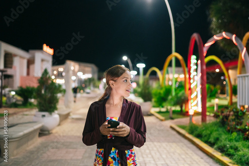 Cuban woman using smartphone in park at night