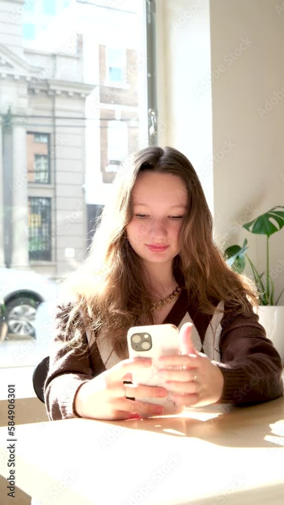 happy Latin American teenage girl checks social media while holding smartphone at home. Smiling young Latin woman using mobile phone playing game shopping online, ordering delivery, relax on couch happy Latin American teenage girl checks social media while holding smartphone at home. Smiling young Latin woman using mobile phone playing game shopping online, ordering delivery, relax on couch
