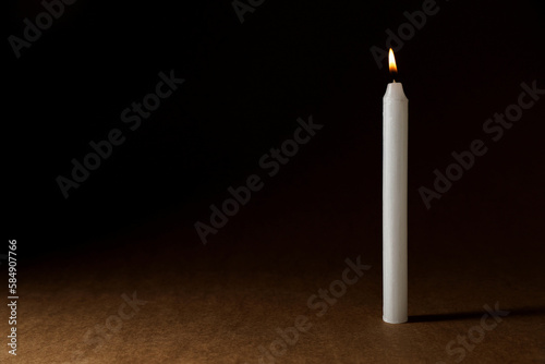 Burning church wax candle on dark background, space for text