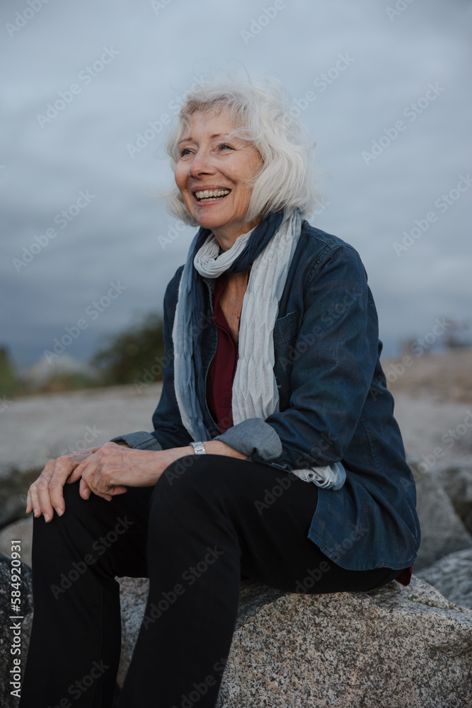 Mature smiling woman enjoying sunset alone. Mature smiling woman enjoying sunset alone.